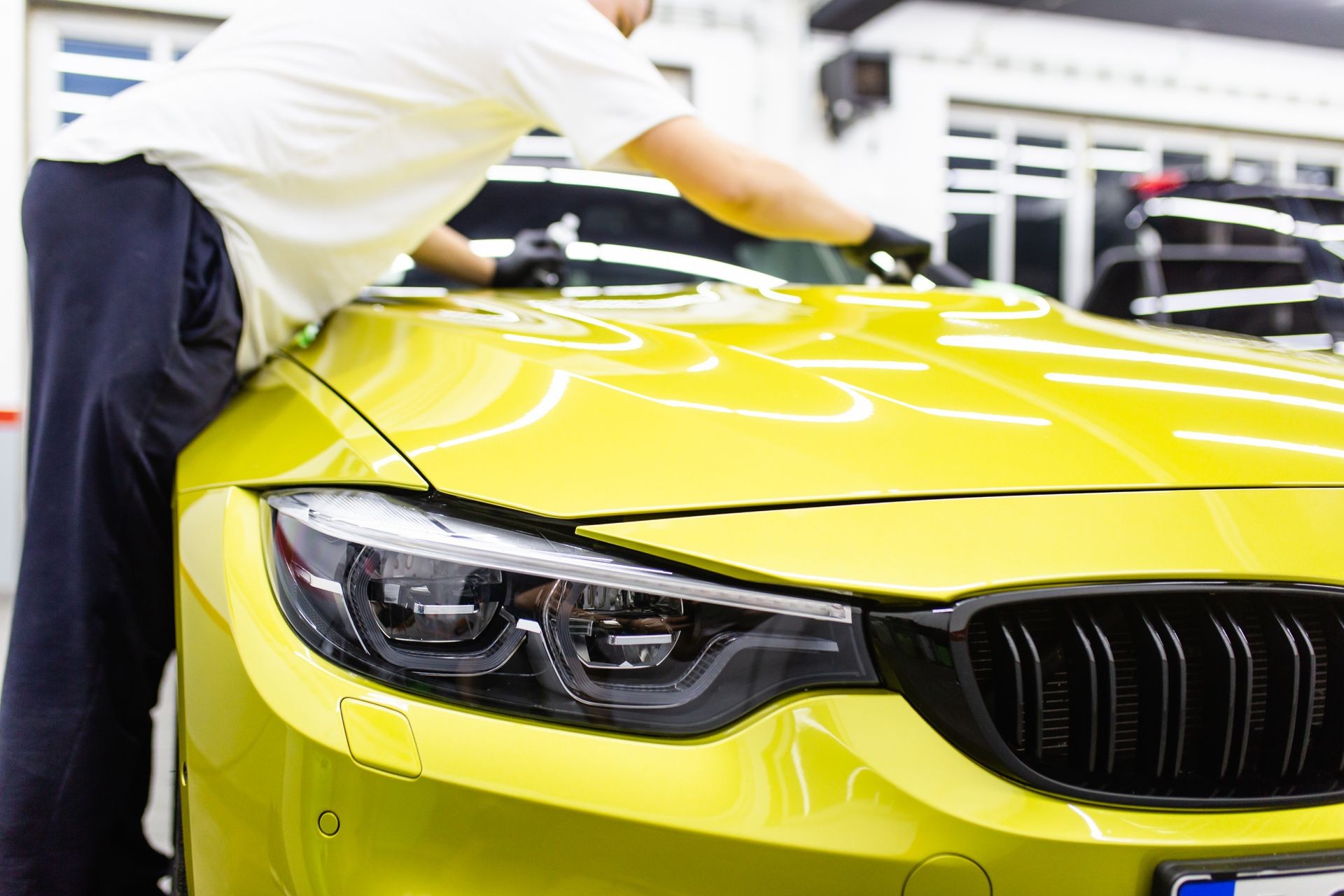 A man cleaning car with microfiber cloth, car detailing (or valeting) concept. Selective focus. A man cleaning car with microfiber cloth, car detailing (or valeting) concept. Selective focus.